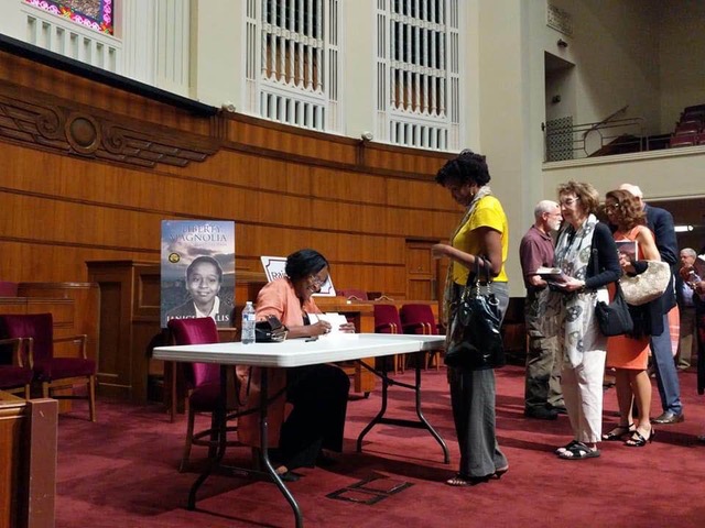 Author happily signs books following the discussion: Photo Credit: Telisa Hassen